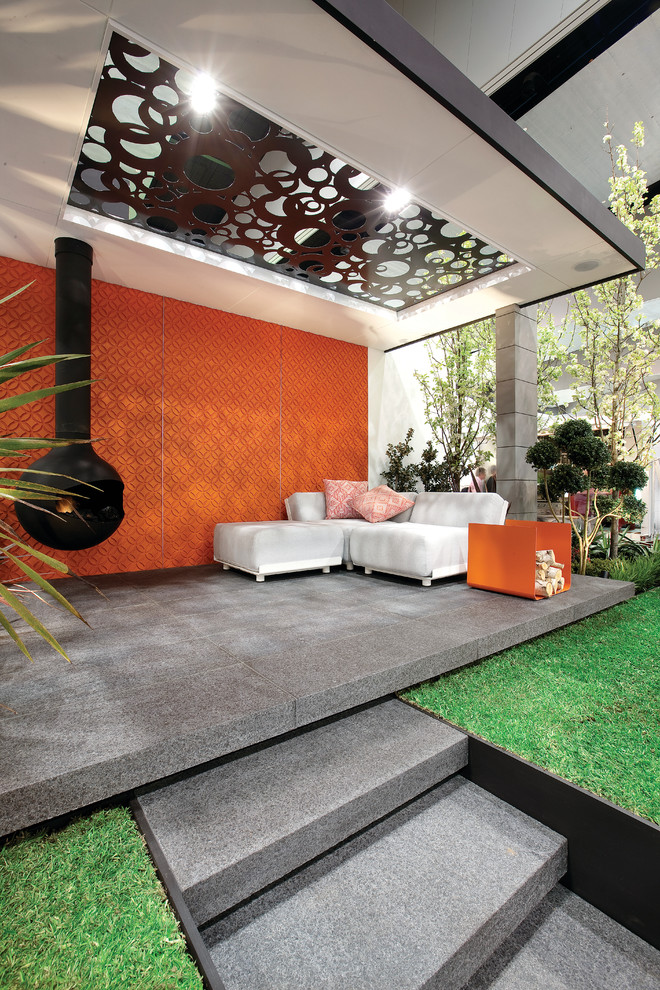 Design ideas for a midcentury patio in Melbourne with with fireplace.