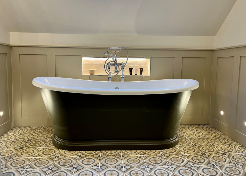 Design ideas for a large country master bathroom in Hertfordshire with shaker cabinets, beige cabinets, a freestanding tub, a corner shower, beige walls, porcelain floors, solid surface benchtops, multi-coloured floor, beige benchtops, a niche, a single vanity and a freestanding vanity.