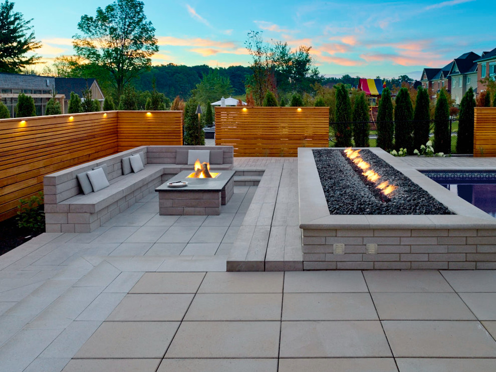 This is an example of an expansive contemporary backyard rectangular pool with with a pool and concrete pavers.