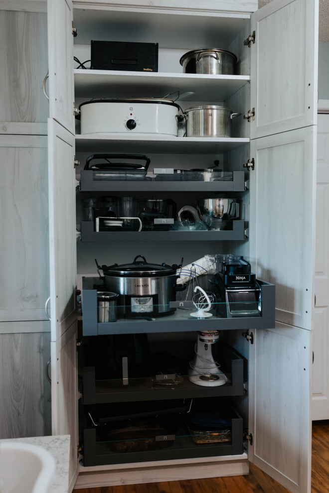 Idéer för ett mellanstort klassiskt grå grovkök, med en undermonterad diskho, skåp i shakerstil, grå skåp, bänkskiva i kvarts, blått stänkskydd, stänkskydd i glaskakel, grå väggar, mellanmörkt trägolv och en tvättmaskin och torktumlare bredvid varandra