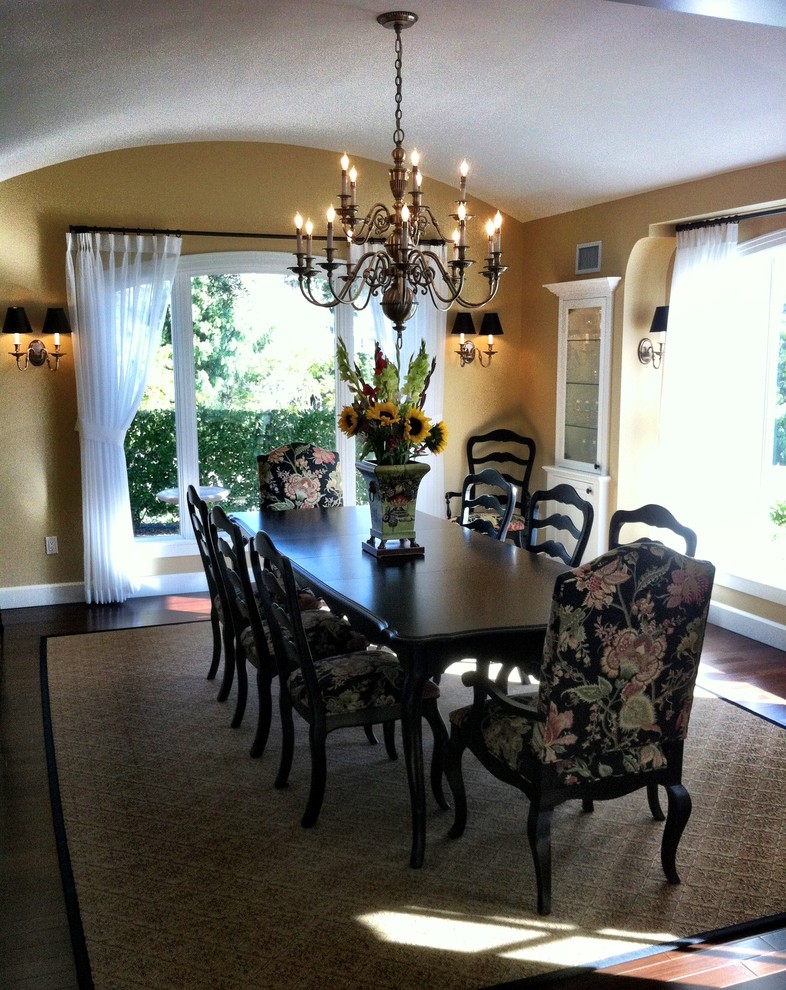 Photo of a mid-sized transitional separate dining room in Los Angeles with yellow walls and dark hardwood floors.