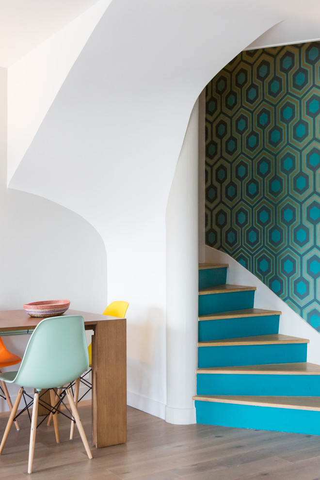 Midcentury wood curved staircase in Paris with painted wood risers.