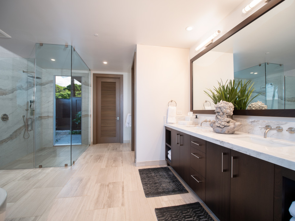 Photo of a large contemporary master bathroom in Hawaii with flat-panel cabinets, brown cabinets, a corner shower, white walls, travertine floors, an undermount sink, granite benchtops, beige floor, a hinged shower door, white benchtops, a double vanity and a built-in vanity.