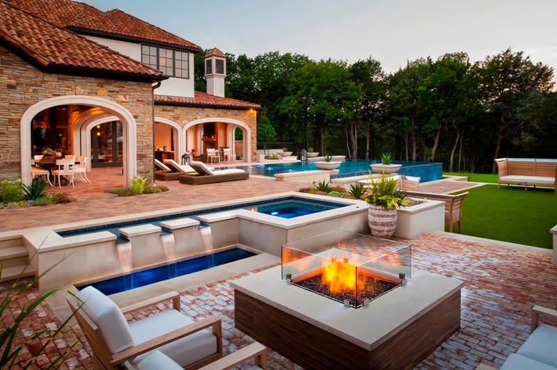 Example of a huge tuscan backyard brick patio fountain design in Dallas with a roof extension