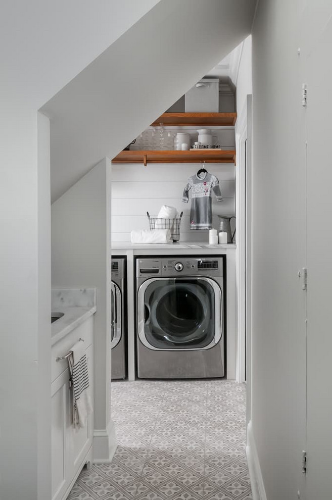 Design ideas for a mid-sized traditional single-wall utility room in Atlanta with a single-bowl sink, shaker cabinets, white cabinets, marble benchtops, grey walls, ceramic floors, a side-by-side washer and dryer, grey floor and white benchtop.