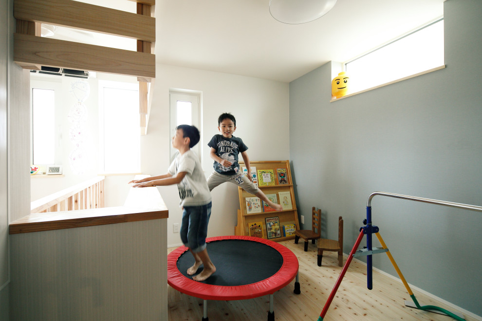 Idéer för ett mellanstort asiatiskt barnrum, med blå väggar och ljust trägolv