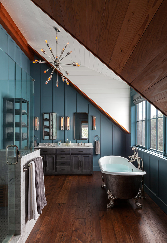 Photo of a country bathroom in San Francisco with shaker cabinets, grey cabinets, a claw-foot tub, blue walls, medium hardwood floors, an undermount sink, brown floor, a hinged shower door and white benchtops.