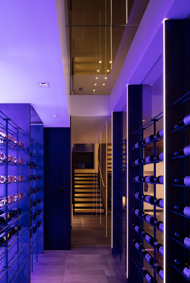 This is an example of a modern wine cellar in Denver with display racks.