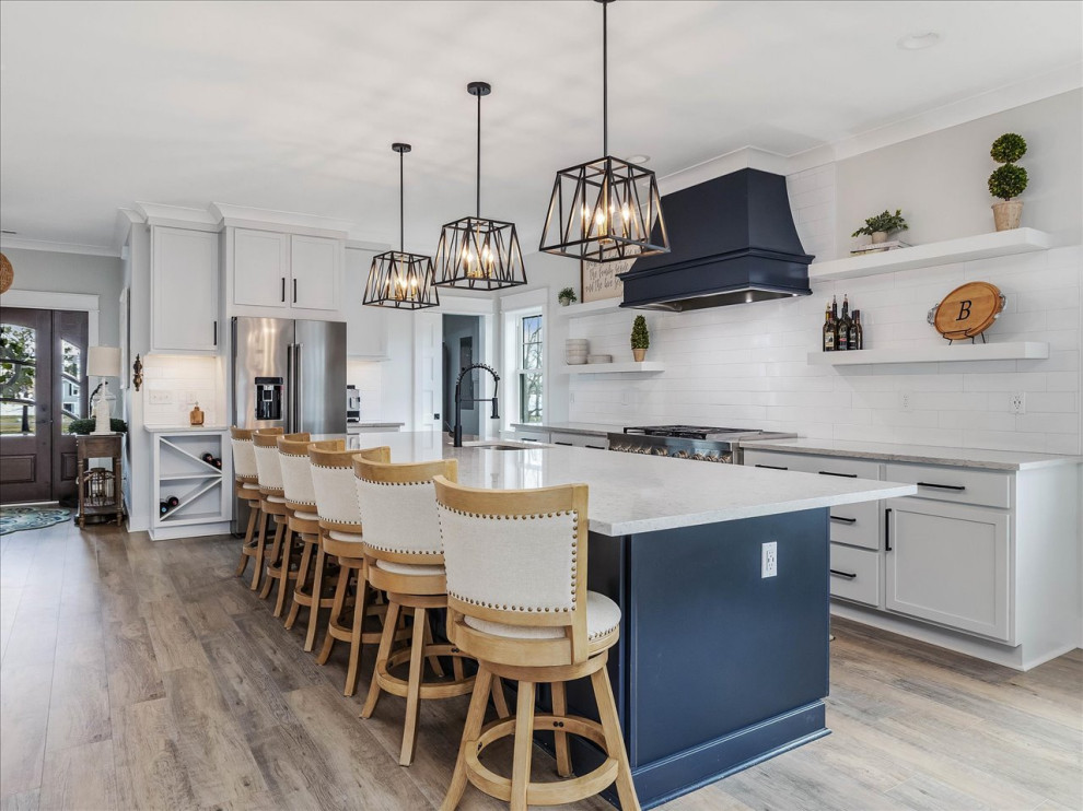 Example of a large beach style l-shaped eat-in kitchen design in DC Metro with an undermount sink, recessed-panel cabinets, white backsplash, subway tile backsplash, stainless steel appliances, an island and multicolored countertops