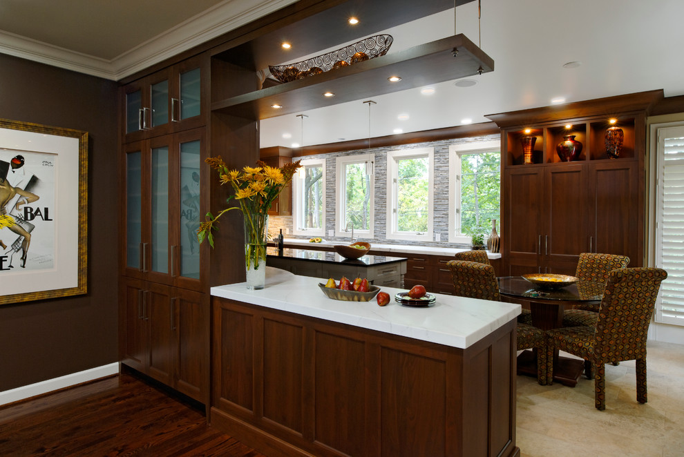 This is an example of a mid-sized traditional l-shaped eat-in kitchen in DC Metro with an undermount sink, beaded inset cabinets, medium wood cabinets, granite benchtops, glass tile splashback, stainless steel appliances, light hardwood floors, with island and multi-coloured splashback.
