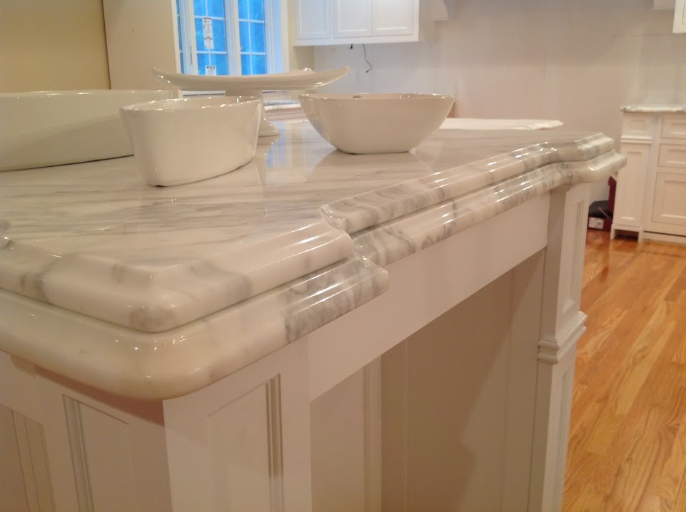 Enclosed kitchen - mid-sized transitional galley medium tone wood floor enclosed kitchen idea in Boston with an undermount sink, beaded inset cabinets, white cabinets, marble countertops, white backsplash, stone tile backsplash, stainless steel appliances and an island