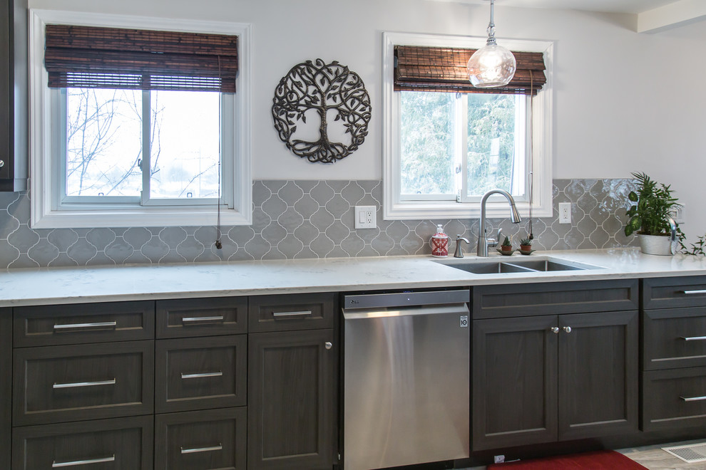 Mid-sized transitional galley porcelain tile and beige floor enclosed kitchen photo in Toronto with an undermount sink, recessed-panel cabinets, dark wood cabinets, quartzite countertops, gray backsplash, ceramic backsplash, stainless steel appliances, no island and white countertops