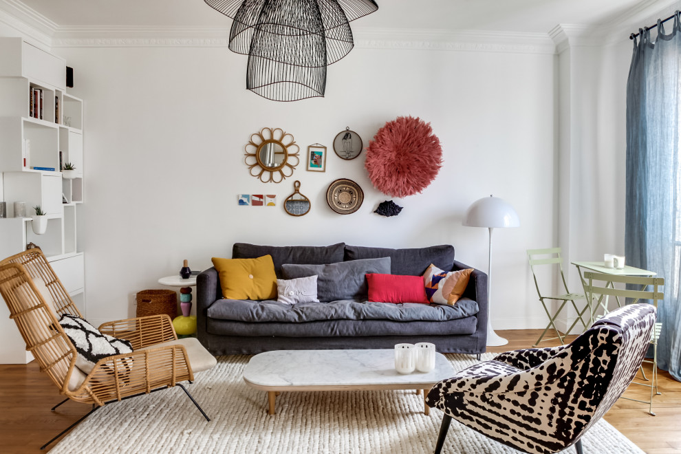 Großes, Offenes Eklektisches Wohnzimmer mit weißer Wandfarbe, braunem Holzboden und freistehendem TV in Paris