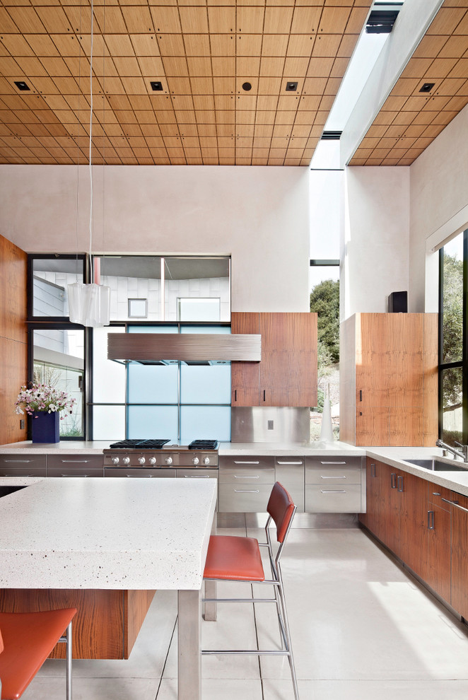 Inspiration for a contemporary kitchen in San Francisco with stainless steel appliances, a single-bowl sink, flat-panel cabinets, stainless steel cabinets, concrete benchtops, metallic splashback and metal splashback.