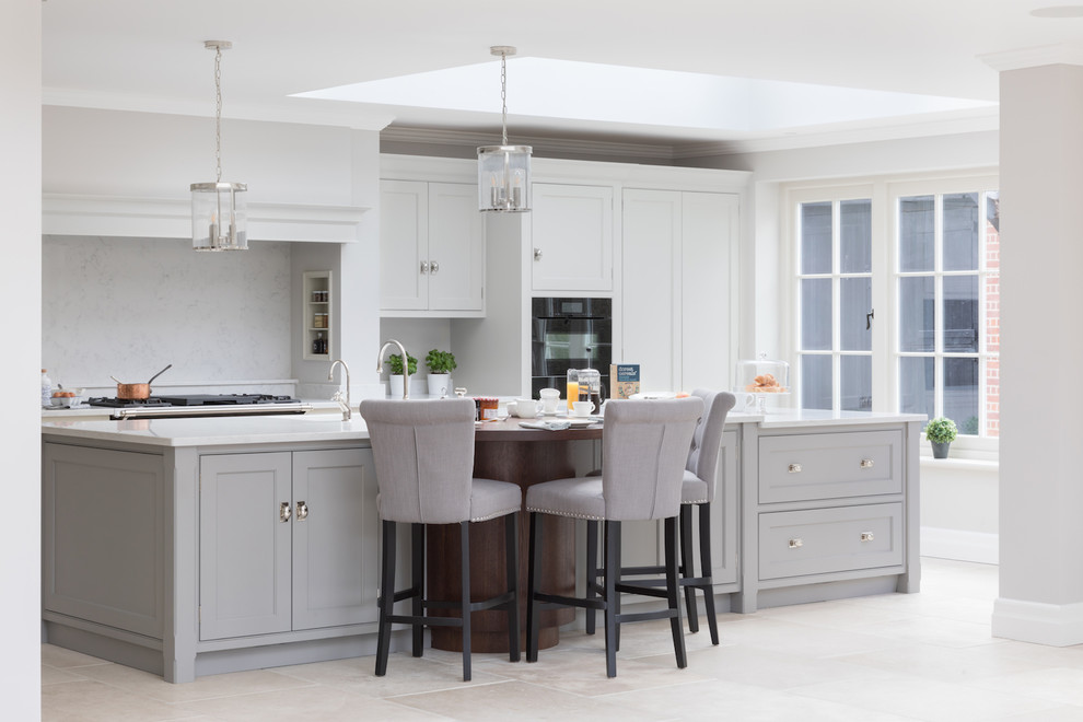 Photo of a large transitional galley kitchen in Other with shaker cabinets, grey cabinets, grey splashback, black appliances, with island, white floor and white benchtop.