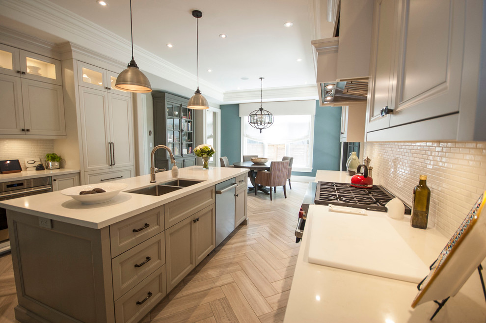 Design ideas for a large transitional galley eat-in kitchen in Toronto with a double-bowl sink, shaker cabinets, white cabinets, quartzite benchtops, white splashback, ceramic splashback, stainless steel appliances, ceramic floors and with island.