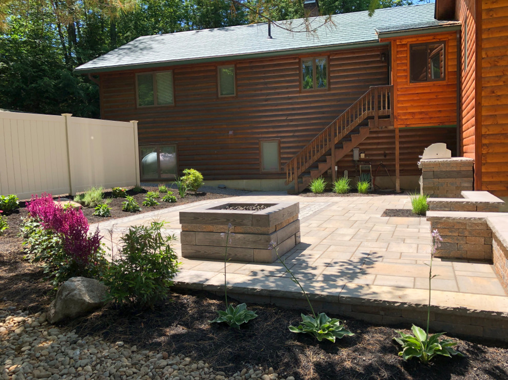 Photo of a mid-sized contemporary backyard full sun formal garden for summer in Boston with a fire feature and concrete pavers.