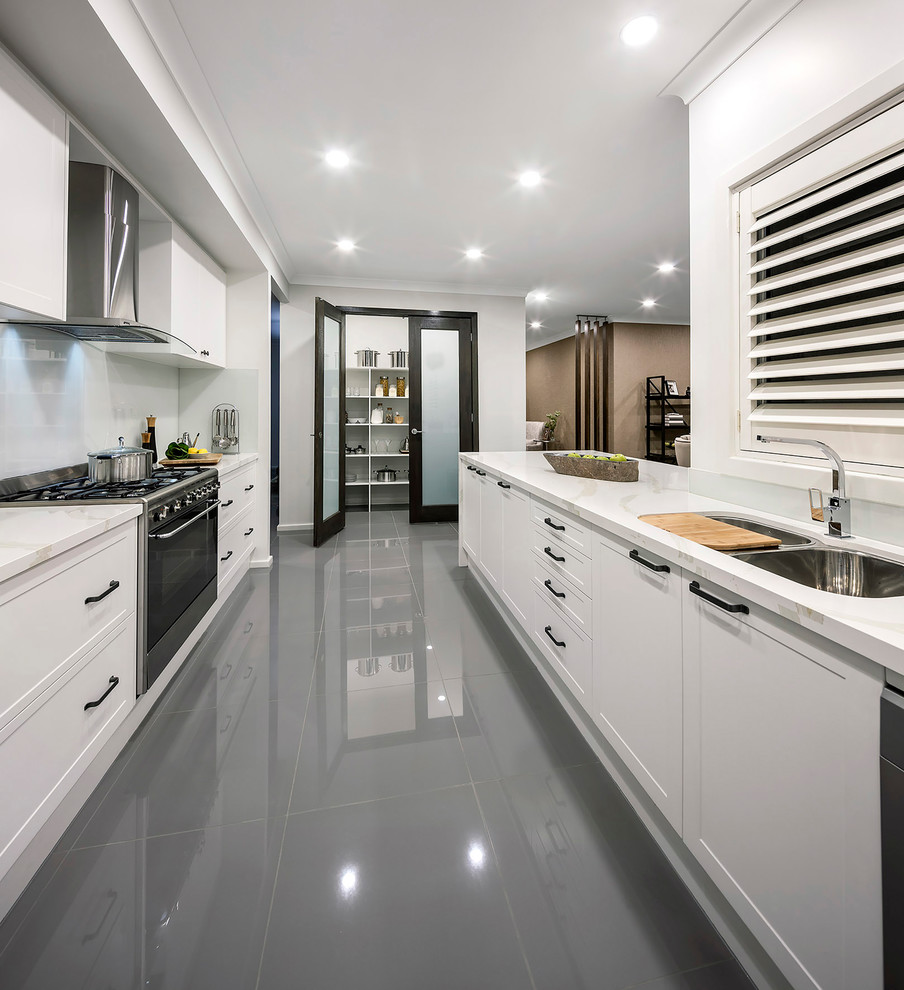 Inspiration for a mid-sized transitional galley kitchen pantry in Newcastle - Maitland with a double-bowl sink, shaker cabinets, white cabinets, quartzite benchtops, grey splashback, glass sheet splashback, stainless steel appliances, porcelain floors, no island and grey floor.