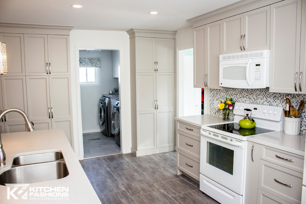 Open concept kitchen - mid-sized transitional single-wall ceramic tile open concept kitchen idea with an undermount sink, shaker cabinets, gray cabinets, solid surface countertops, gray backsplash, mosaic tile backsplash, white appliances and an island