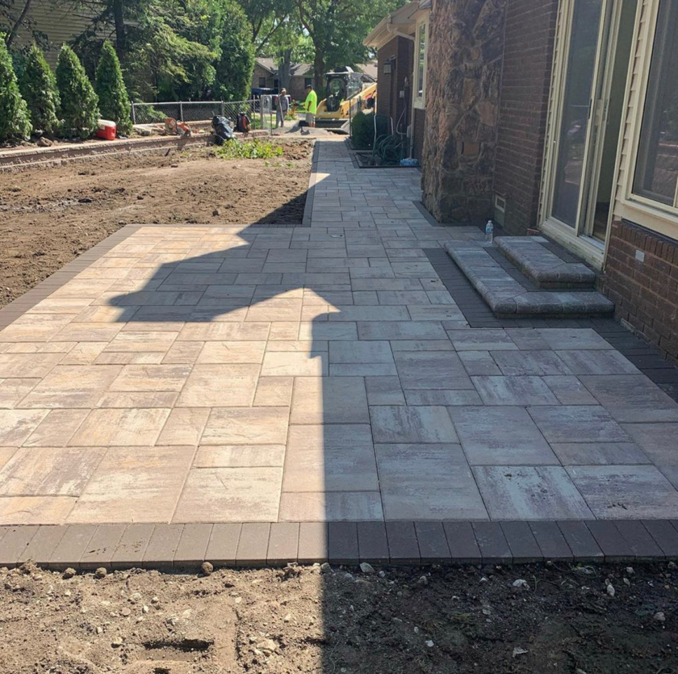 Design ideas for a large transitional backyard patio in Detroit with concrete pavers and no cover.