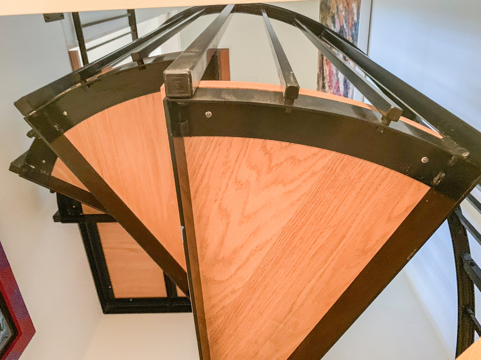 Small contemporary wood spiral staircase in DC Metro with metal railing.