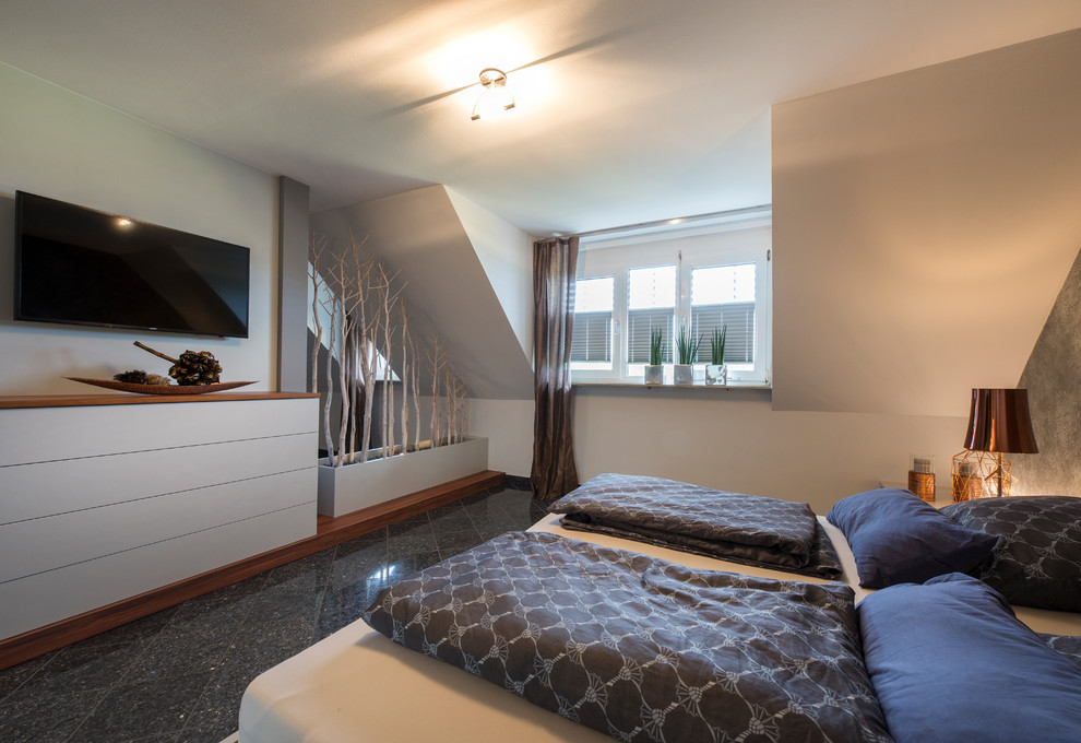 Photo of a mid-sized contemporary bedroom in Nuremberg with white walls, no fireplace and black floor.