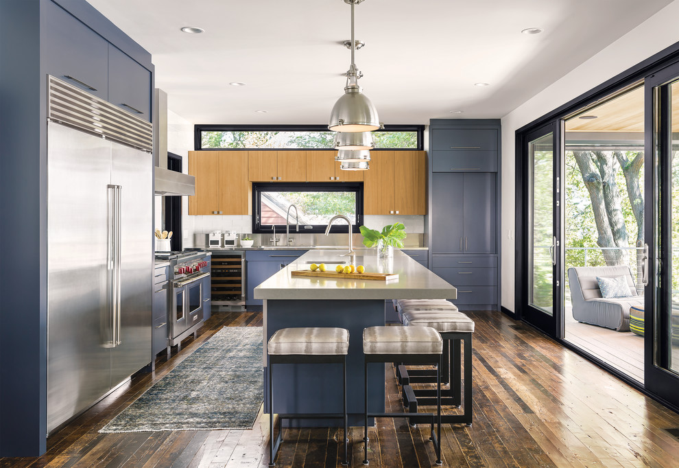 Design ideas for a large contemporary l-shaped open plan kitchen in Portland Maine with flat-panel cabinets, blue cabinets, white splashback, subway tile splashback, stainless steel appliances, medium hardwood floors and with island.