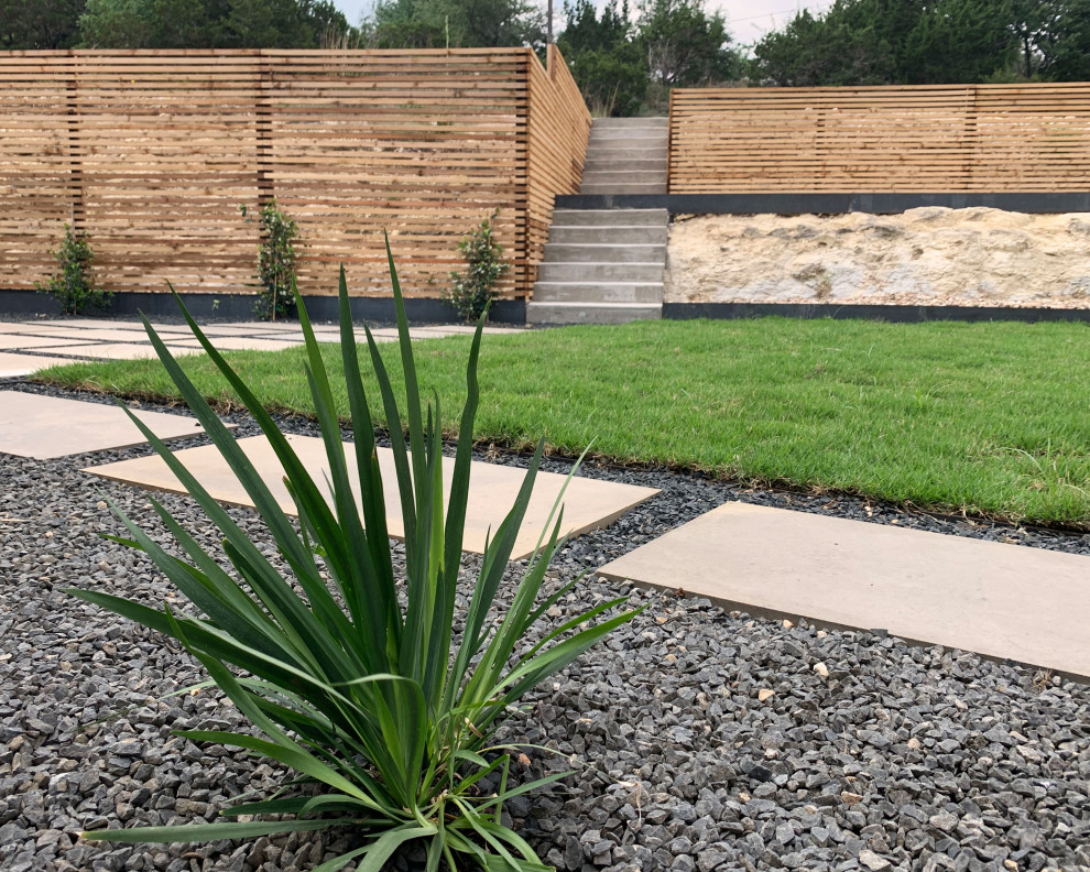 Cette image montre un jardin arrière design de taille moyenne et l'été avec une exposition ensoleillée, des pavés en béton et une clôture en bois.