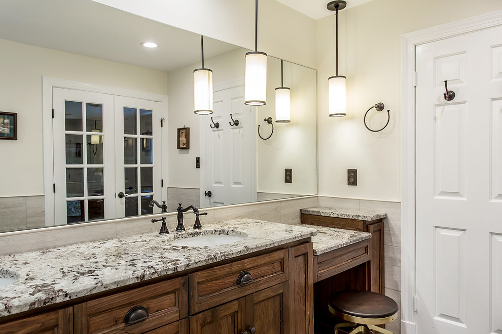Photo of a large country master bathroom in Richmond with dark wood cabinets, a corner shower, a two-piece toilet, beige tile, porcelain tile, grey walls, porcelain floors, an undermount sink, granite benchtops, grey floor, a hinged shower door and shaker cabinets.
