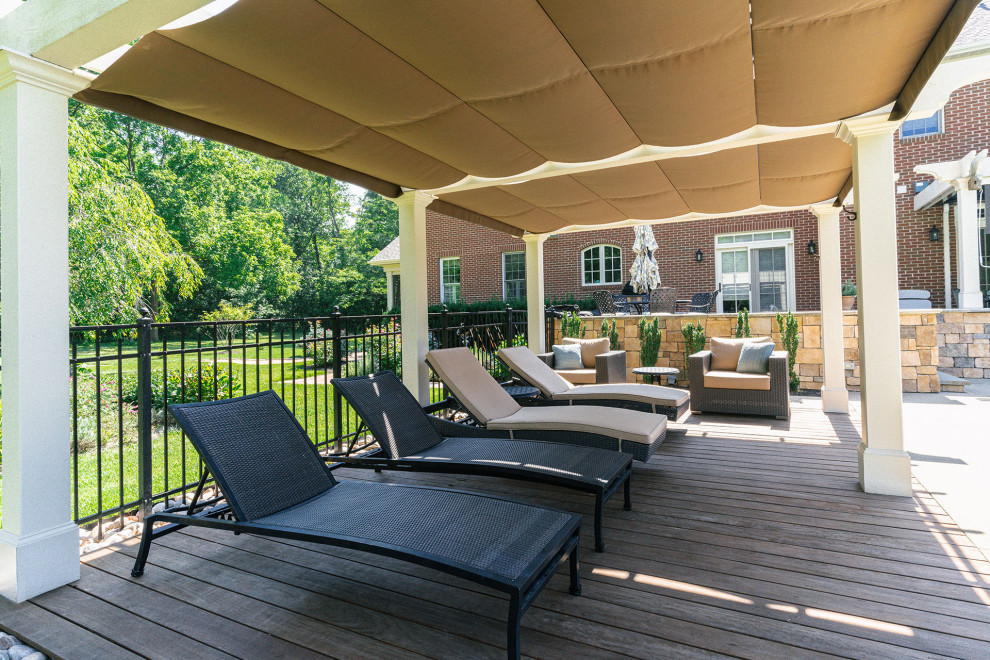 Inspiration for a timeless backyard ground level privacy and metal railing deck remodel in Columbus with a pergola