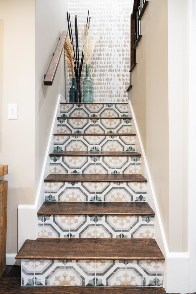 This is an example of an eclectic wood u-shaped staircase in Boston with tile risers, mixed railing and wallpaper.