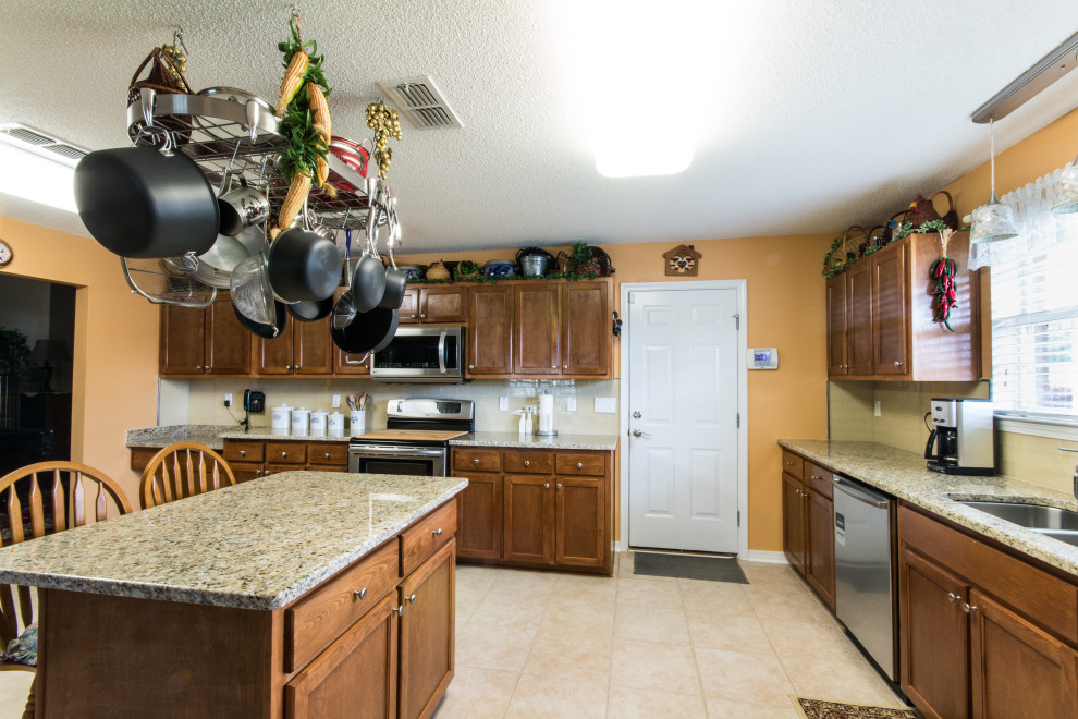 Large l-shaped ceramic tile and beige floor eat-in kitchen photo with an undermount sink, flat-panel cabinets, brown cabinets and an island