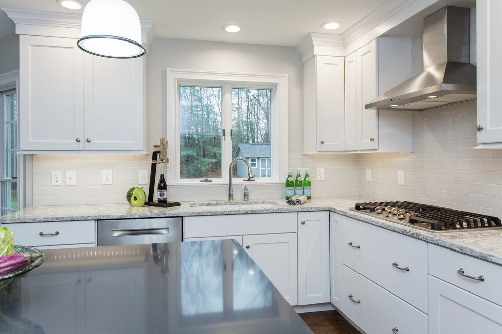 Inspiration for a mid-sized transitional u-shaped dark wood floor enclosed kitchen remodel in Boston with an undermount sink, recessed-panel cabinets, white cabinets, quartz countertops, gray backsplash, subway tile backsplash, stainless steel appliances and an island