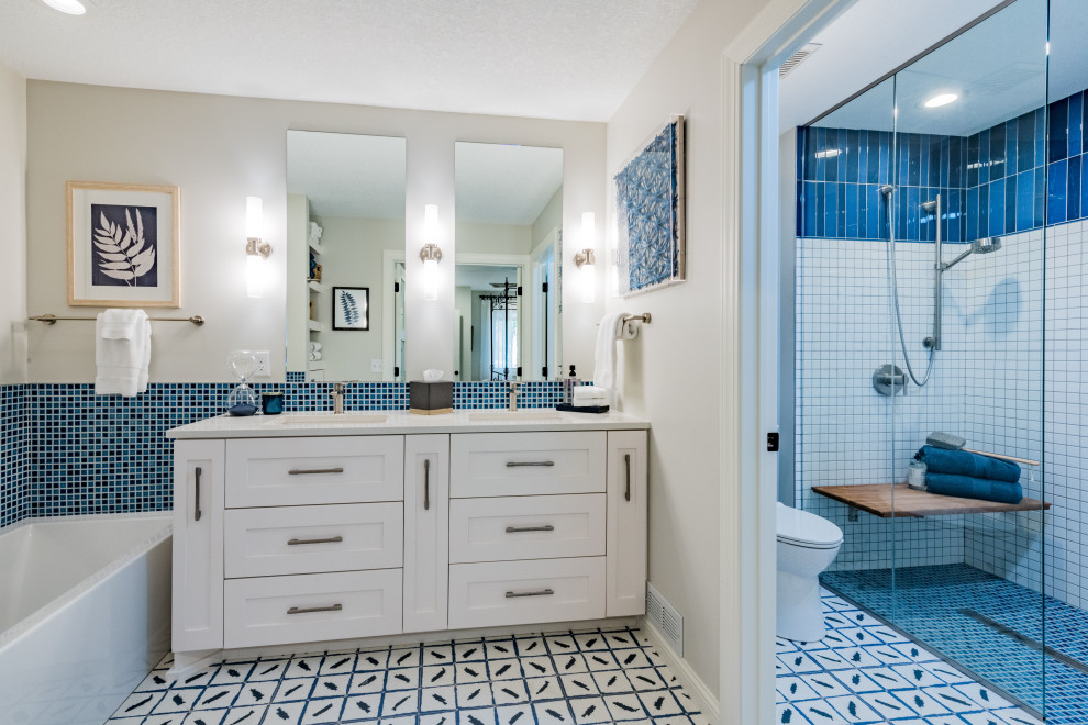 Стильный дизайн: главная ванная комната среднего размера в стиле неоклассика (современная классика) с фасадами в стиле шейкер, белыми фасадами, ванной в нише, душем без бортиков, унитазом-моноблоком, синей плиткой, керамогранитной плиткой, серыми стенами, полом из керамогранита, врезной раковиной, столешницей из кварцита, разноцветным полом, открытым душем, белой столешницей, сиденьем для душа, тумбой под две раковины и встроенной тумбой - последний тренд