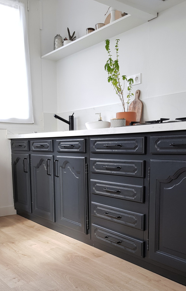 This is an example of a contemporary single-wall separate kitchen in Dijon with black cabinets and laminate floors.