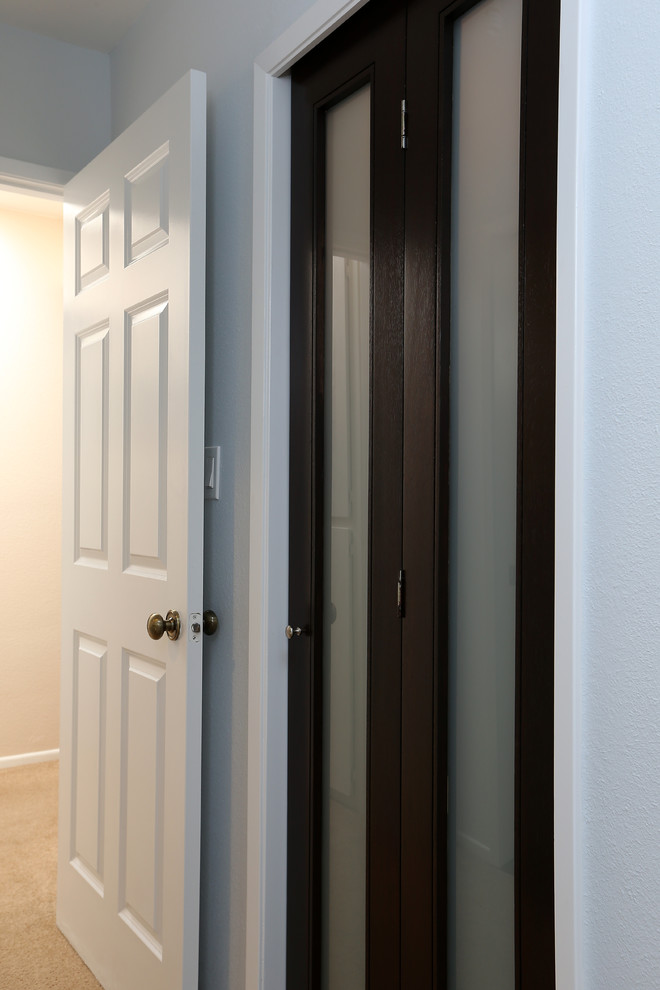 Photo of a mid-sized modern women's walk-in wardrobe in Los Angeles with flat-panel cabinets, dark wood cabinets and porcelain floors.