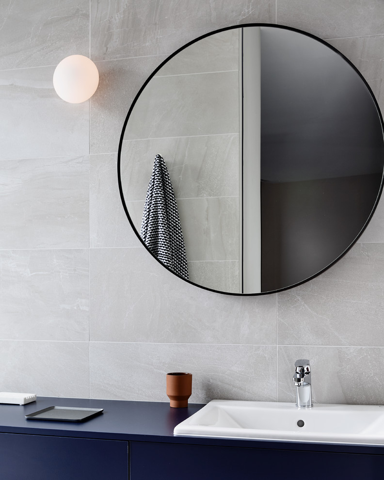 Large contemporary bathroom in Melbourne with flat-panel cabinets, blue cabinets, an alcove shower, a wall-mount toilet, gray tile, ceramic tile, grey walls, ceramic floors, a drop-in sink, laminate benchtops, grey floor, an open shower and blue benchtops.