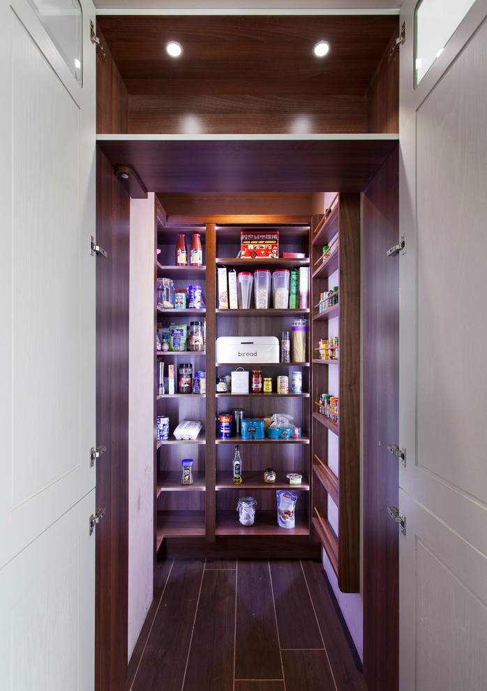 This is an example of a medium sized traditional open plan kitchen with a built-in sink, grey cabinets, an island, brown floors and dark hardwood flooring.