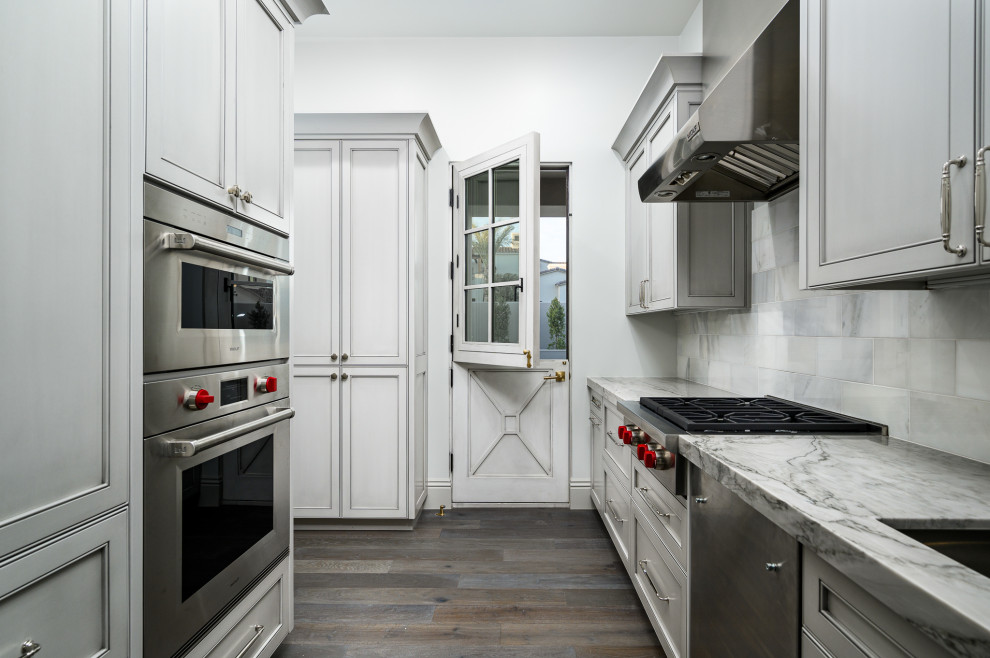 Kitchen - huge modern u-shaped marble floor, gray floor and coffered ceiling kitchen idea in Phoenix with a drop-in sink, gray cabinets, marble countertops, gray backsplash, stone tile backsplash, colored appliances, two islands and gray countertops
