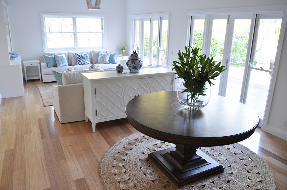 Photo of a traditional living room in Brisbane with white walls and light hardwood floors.