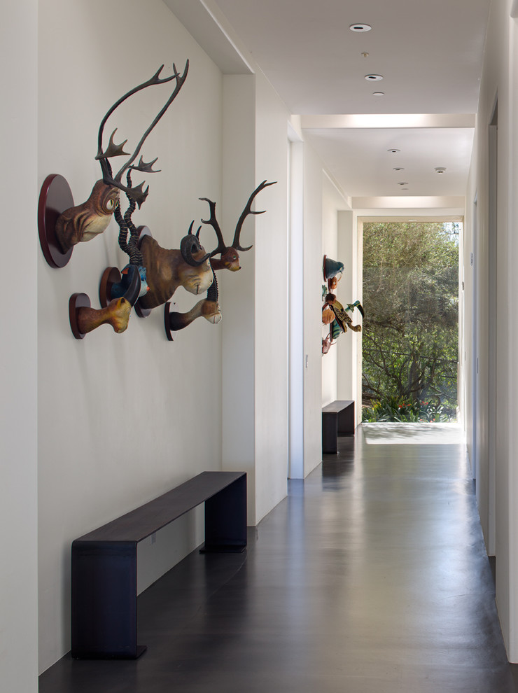 Photo of a large eclectic hallway in San Diego with white walls, concrete floors and grey floor.