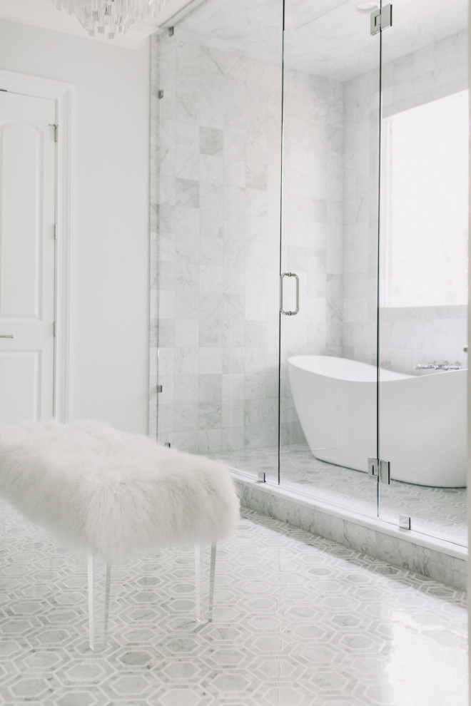 На фото: большая главная ванная комната в стиле неоклассика (современная классика) с фасадами в стиле шейкер, серыми фасадами, отдельно стоящей ванной, душевой комнатой, унитазом-моноблоком, серой плиткой, мраморной плиткой, серыми стенами, мраморным полом, врезной раковиной, мраморной столешницей, серым полом, душем с распашными дверями, белой столешницей, сиденьем для душа, тумбой под две раковины, встроенной тумбой и многоуровневым потолком с