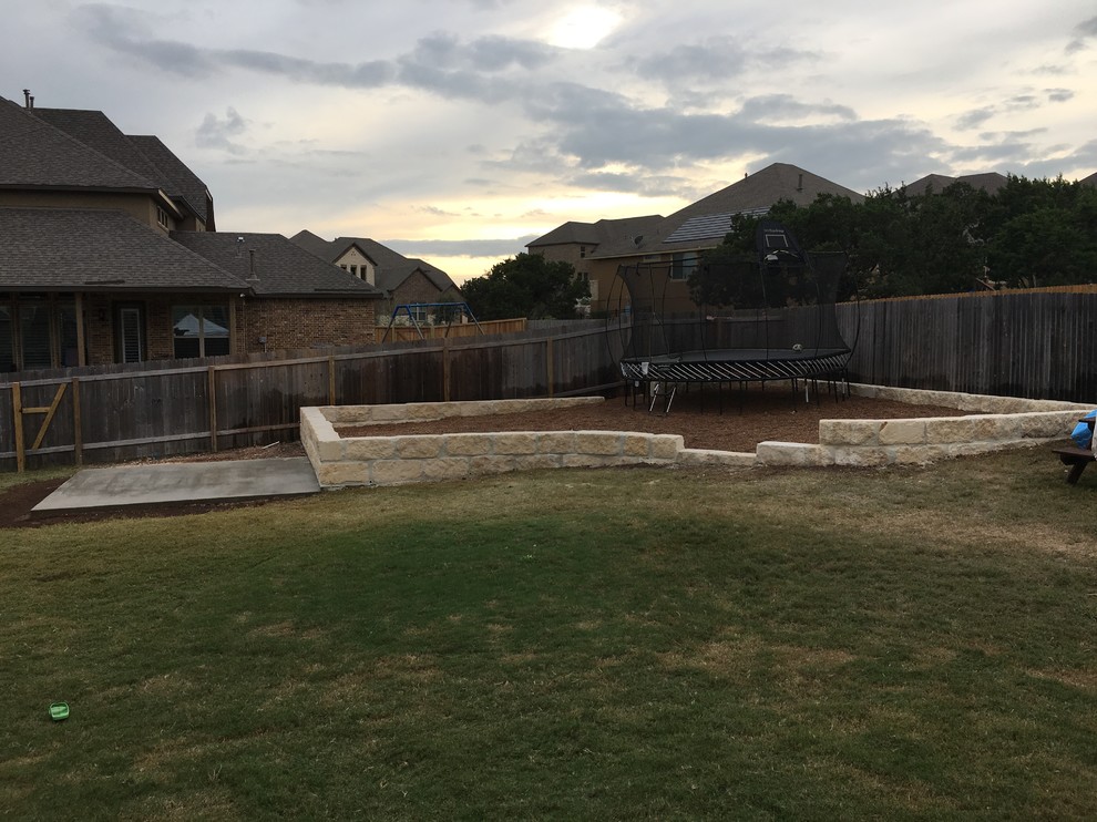 Photo of a mid-sized rustic stone retaining wall landscape.
