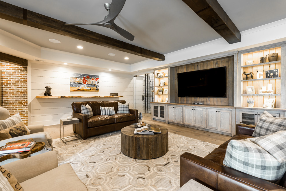 Country family room in Atlanta with white walls, light hardwood floors and brown floor.