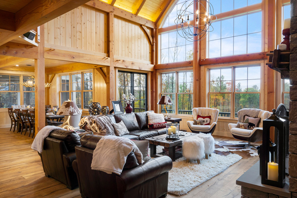 This is an example of a large country open concept living room in Boston with medium hardwood floors, a standard fireplace and a stone fireplace surround.