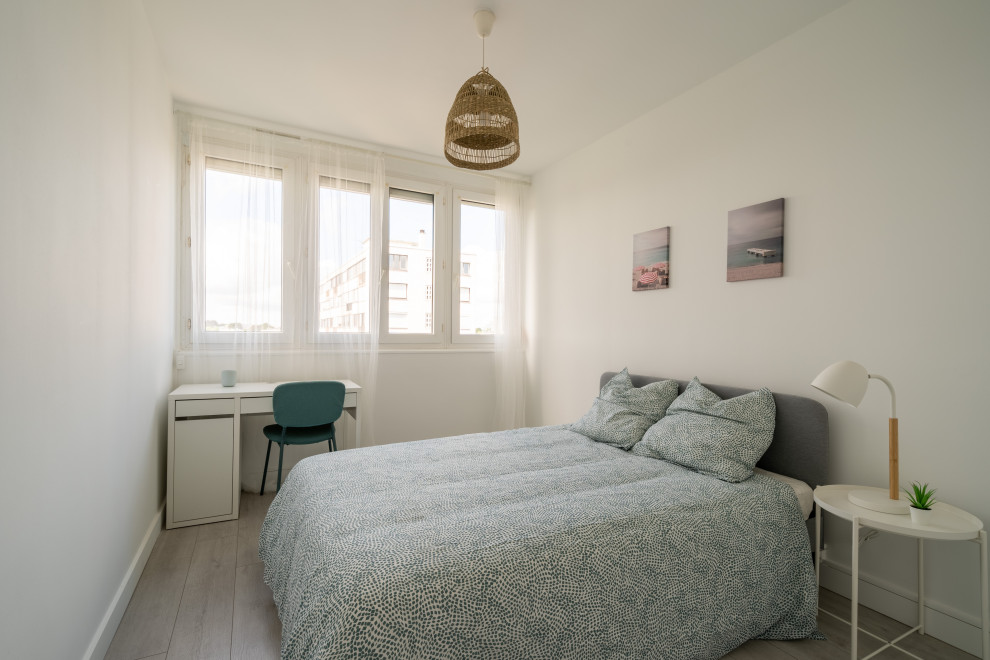 Photo of a mid-sized contemporary guest bedroom in Nantes with white walls, light hardwood floors, no fireplace and grey floor.