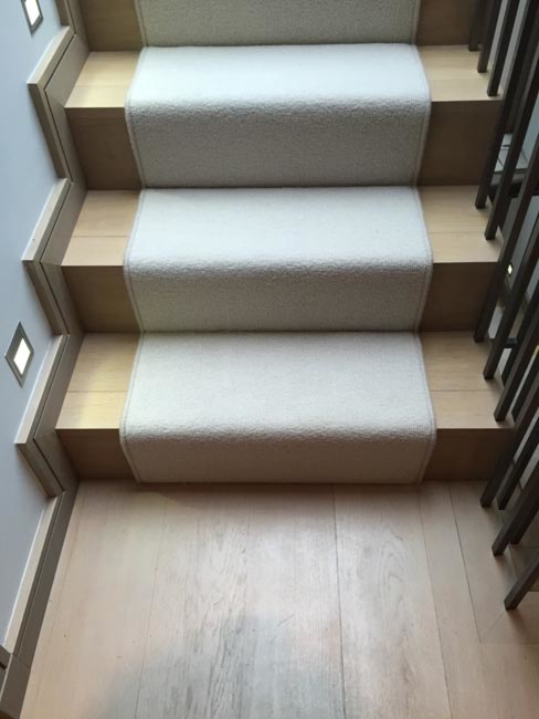 This is an example of a transitional carpeted curved staircase in London with carpet risers.