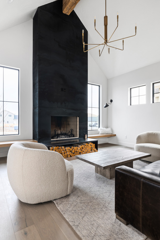This is an example of a medium sized scandi open plan living room in Boise with white walls, light hardwood flooring, a wood burning stove, a metal fireplace surround, no tv, beige floors and a vaulted ceiling.