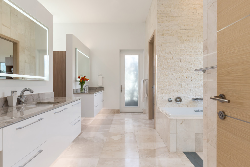 Inspiration for a large contemporary master wet room bathroom in Tampa with flat-panel cabinets, white cabinets, a japanese tub, a one-piece toilet, beige tile, white walls, travertine floors, an undermount sink, marble benchtops, beige floor, an open shower and travertine.