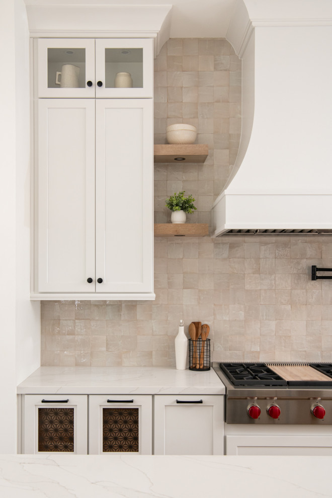 Inspiration for a transitional vinyl floor and brown floor enclosed kitchen remodel in Orange County with a farmhouse sink, shaker cabinets, white cabinets, quartz countertops, beige backsplash, terra-cotta backsplash, stainless steel appliances, an island and white countertops